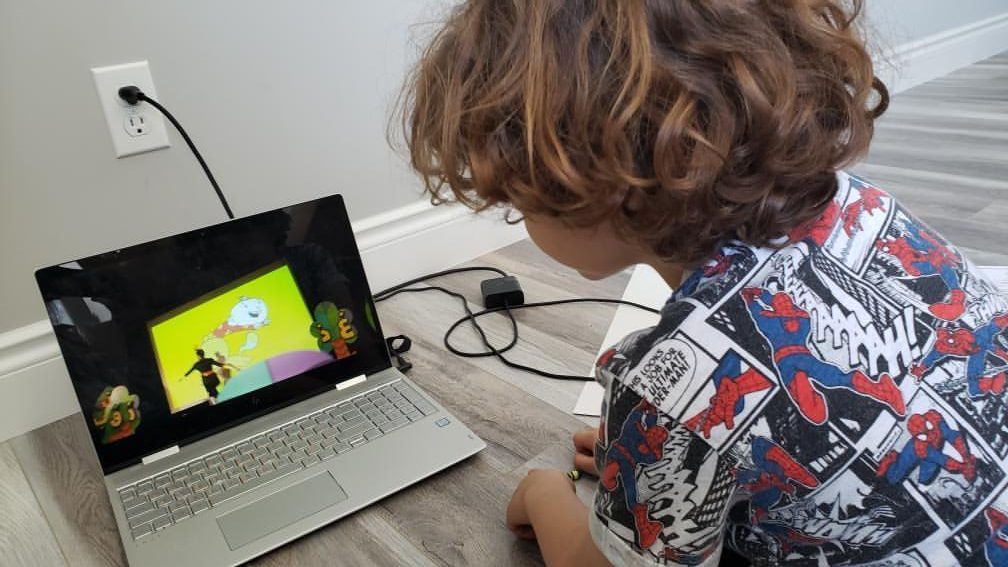 Child watching Adam Wa Mishmish play on laptop